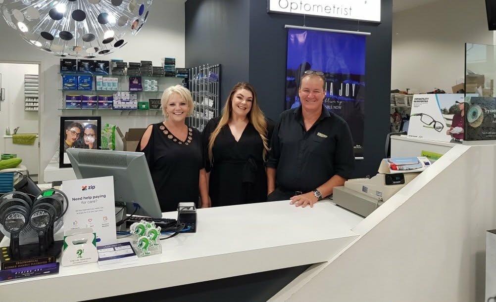 Greg Luke with his optometry practice team behind the counter in Coffs Harbour